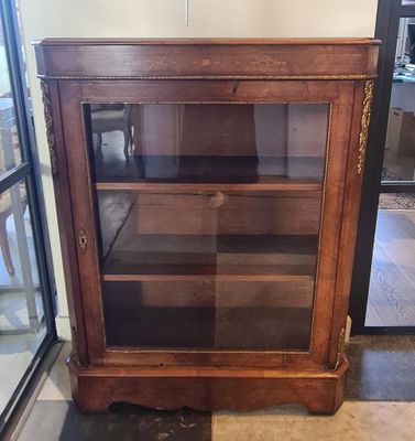 un meuble en bois avec une porte en verre dans une pièce