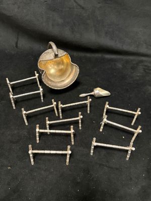 des échelles miniatures plaquées argent et une théière en argent sur fond noir