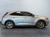 the silver suv is parked in a room with a gray wall