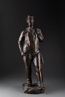 une statue en bronze représentant un homme debout sur un rocher