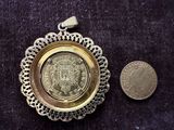 a small coin sitting next to a coin on a table