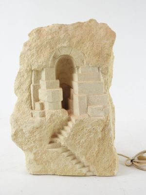 a stone sculpture of a castle on a white surface