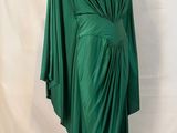 a green draped dress on a mannequin base with a white background