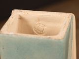 a blue vase with a white base on a table