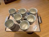 un plateau sur lequel sont posées six tasses, posé sur une table