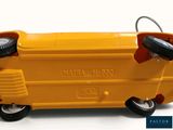 a yellow toy truck with wheels on a white surface