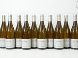 six bouteilles de vin sont alignées sur une surface blanche
