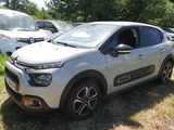 une petite voiture blanche garée dans l'herbe à côté d'autres voitures
