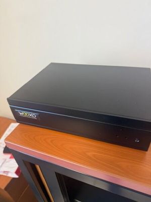a black dvd player sitting on top of a wooden table