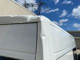 a white van parked in front of a building under a blue sky