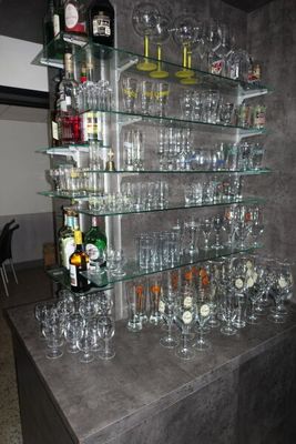 de nombreux verres et bouteilles posés sur le comptoir dans la pièce