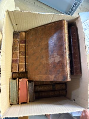 une boîte remplie de vieux livres posée sur une table