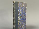 un vieux livre à la couverture bleue posé sur une table