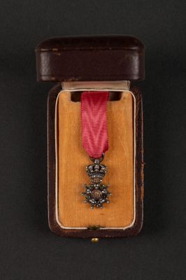 medal in a case on a black background with a red ribbon