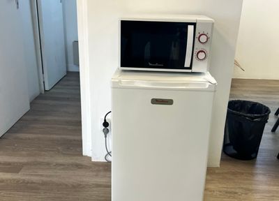 un petit réfrigérateur blanc surmonté d'un micro-ondes