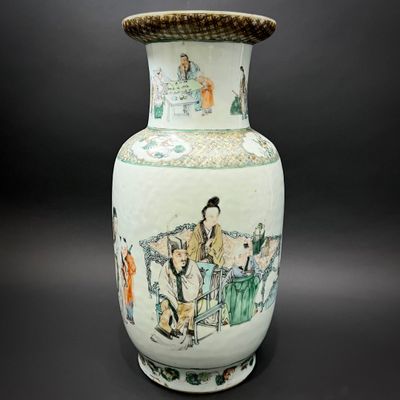 a vase with a painting on it sitting on a table