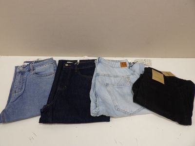 quatre paires de jeans sont alignées sur une table