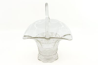 a glass vase with a spoon in it on a white surface