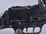 an old machine gun with a wooden handle on a white surface