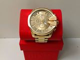 a gold watch on a red box on a white surface