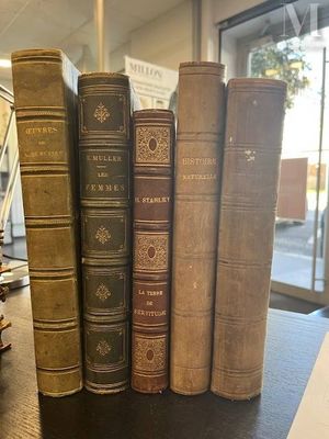 several old books are stacked on top of each other on a table
