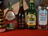 several bottles of alcohol are lined up on a red table