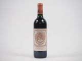 la bouteille de vin rouge est posée sur une surface blanche