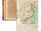 un livre ouvert, sur lequel figure une carte, posé sur une table
