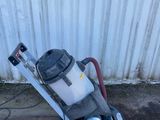 un aspirateur posé par terre près d'un mur
