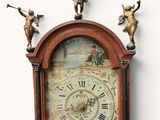 a clock that is on the wall with angels on it