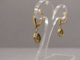 pair of gold tone earrings with blue stones on clear acrylic stand