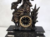 une statue représentant une femme tenant une horloge posée sur un socle