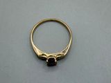 an image of a gold ring with a black stone