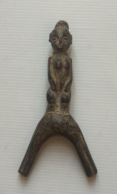 statue représentant une femme assise sur un objet métallique