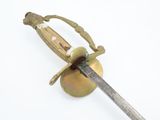 a gold colored sword with a handle on a white surface