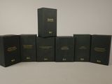 six black boxes with gold lettering are stacked on top of each other