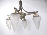 a chandelier with three glass shades hanging from the ceiling