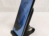 a close up of a cell phone on a stand on a white surface