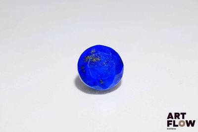 gros plan d'une pierre bleue sur une surface blanche