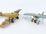 deux petits avions en plastique posés l'un à côté de l'autre sur une surface blanche