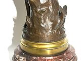 statue of a woman holding a bird on a marble base