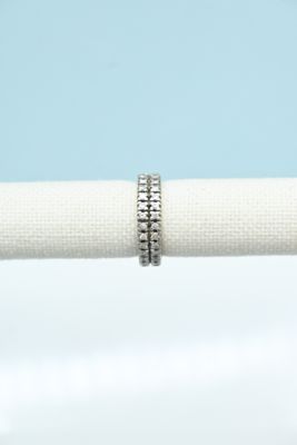 a close up of a white napkin with a silver ring on it