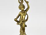 an antique brass candle holder with a man holding a bowl