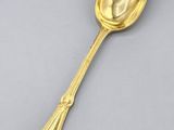 a close up of a gold spoon on a gray surface