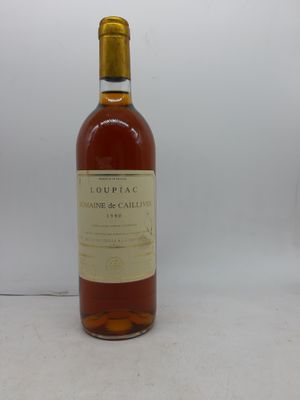 La bouteille d'alcool est posée sur la table près du mur.