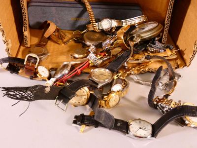 une valise remplie de montres de toutes sortes et d'autres objets
