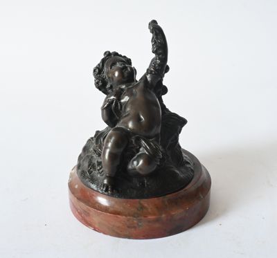 bronze figurine of a child on a rock holding a bird