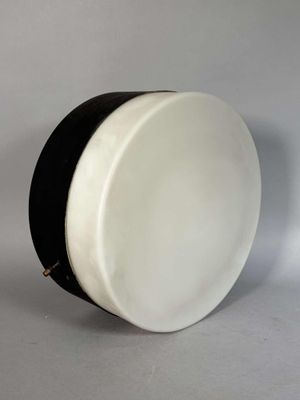 un tambour blanc et noir posé sur une surface blanche