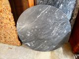a marble table top sitting on the floor next to other marbles