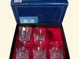 four glasses in a box with a red cloth inside